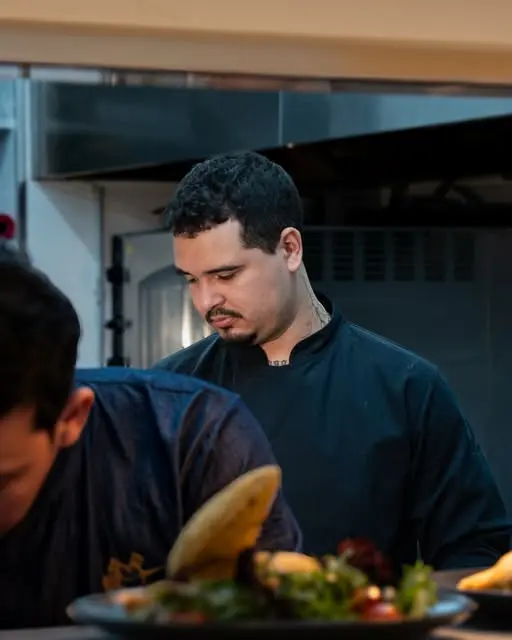 O Chef Sarano no passe da cozinha, a preparar um prato.