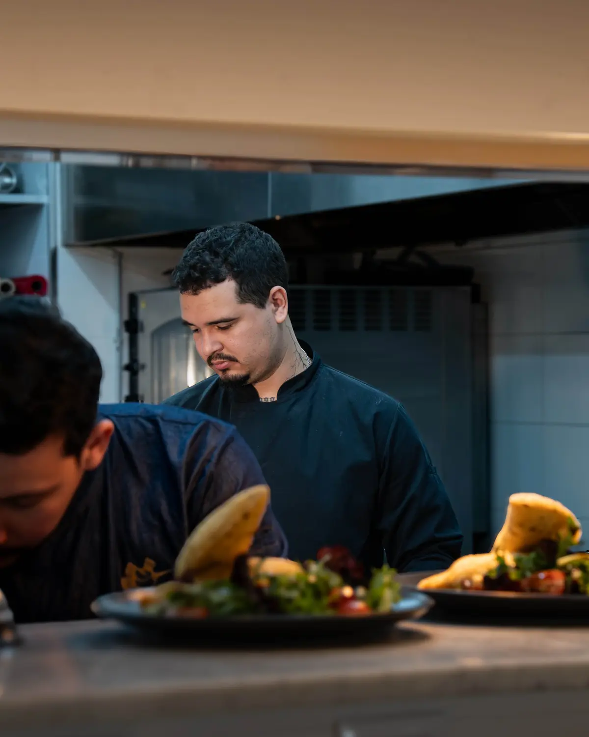O Chef Sarano a empratar saladas durante um serviço.